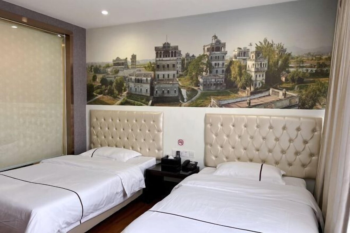 A hotel room with two beds, a mural of a historical building, and a no-smoking sign.