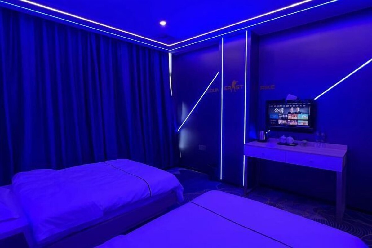 A room with two beds, a desk, and a television.