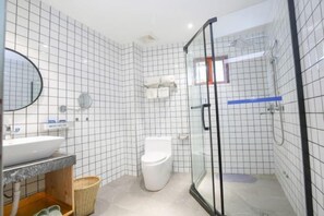 A modern bathroom with a glass shower enclosure, a white toilet, and a marble sink.