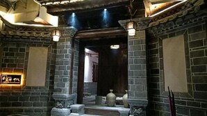 A traditional-style interior with stone walls, a wooden door, and a sign with Chinese characters.
