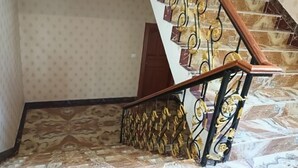 A staircase with a patterned floor and a metal railing with decorative elements. - Reshuitang Hotel (Li County)