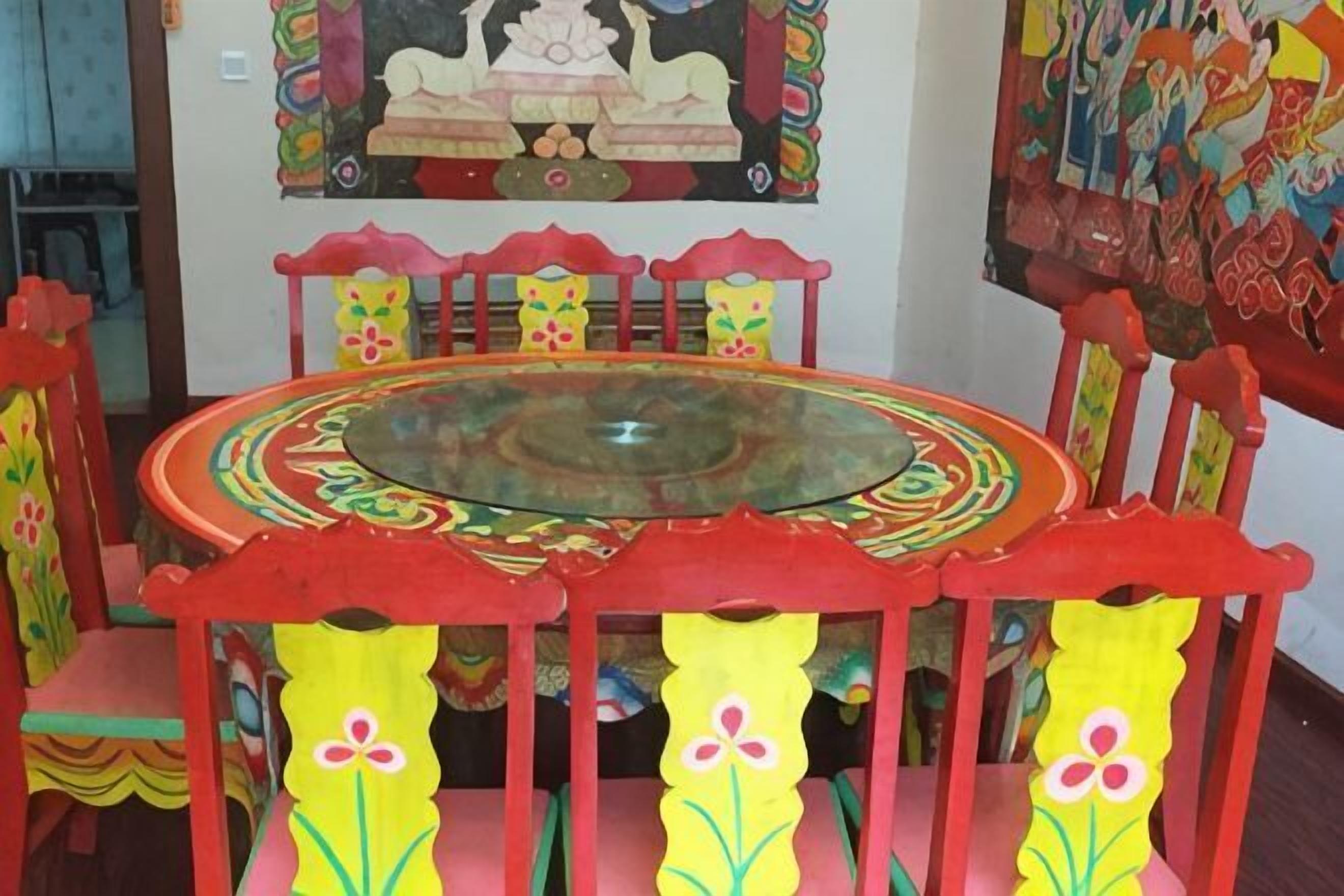 Uma mesa redonda com tampo de vidro, rodeada por cadeiras com desenhos florais.