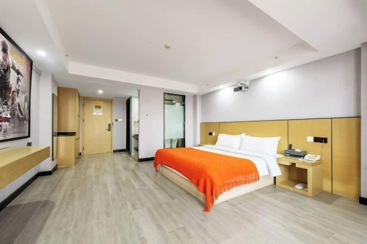 Une chambre d’hôtel équipée d’un lit, d’une table de chevet et d’un téléphone fixé au mur.