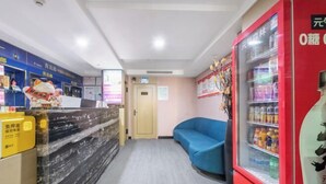 Un espace d’accueil avec un comptoir en marbre, un canapé bleu et un distributeur de boissons rouge.