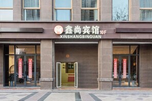 A building with a sign reading 'XINSHANGBINGUAN' and a large entrance. - Xinshang Cinema Hotel (Yancheng Zhongnan City University Town Branch) (Yancheng)