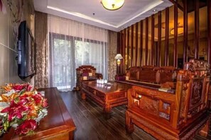 Work or unwind in a room designed for productivity and relaxation, featuring a large desk, TV, and window.