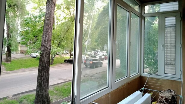 Ein Zimmer mit großen Fenstern, einer Holzbank und einem Wäscheständer.