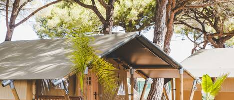 A wooden cabin with a covered porch, a bench, and a table.