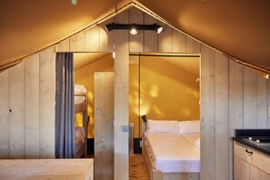 A cozy attic bedroom with a wooden sloped ceiling, a bunk bed, and a small desk area. - TAIGA Conil (Conil de la Frontera)