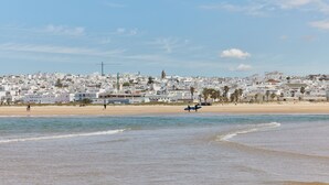 A coastal town with white buildings, a beach, and a clear sky. - TAIGA Conil (Conil de la Frontera)