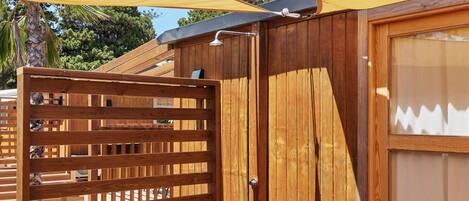 A wooden outdoor area with a wooden gate, a wooden door, and a wooden deck.