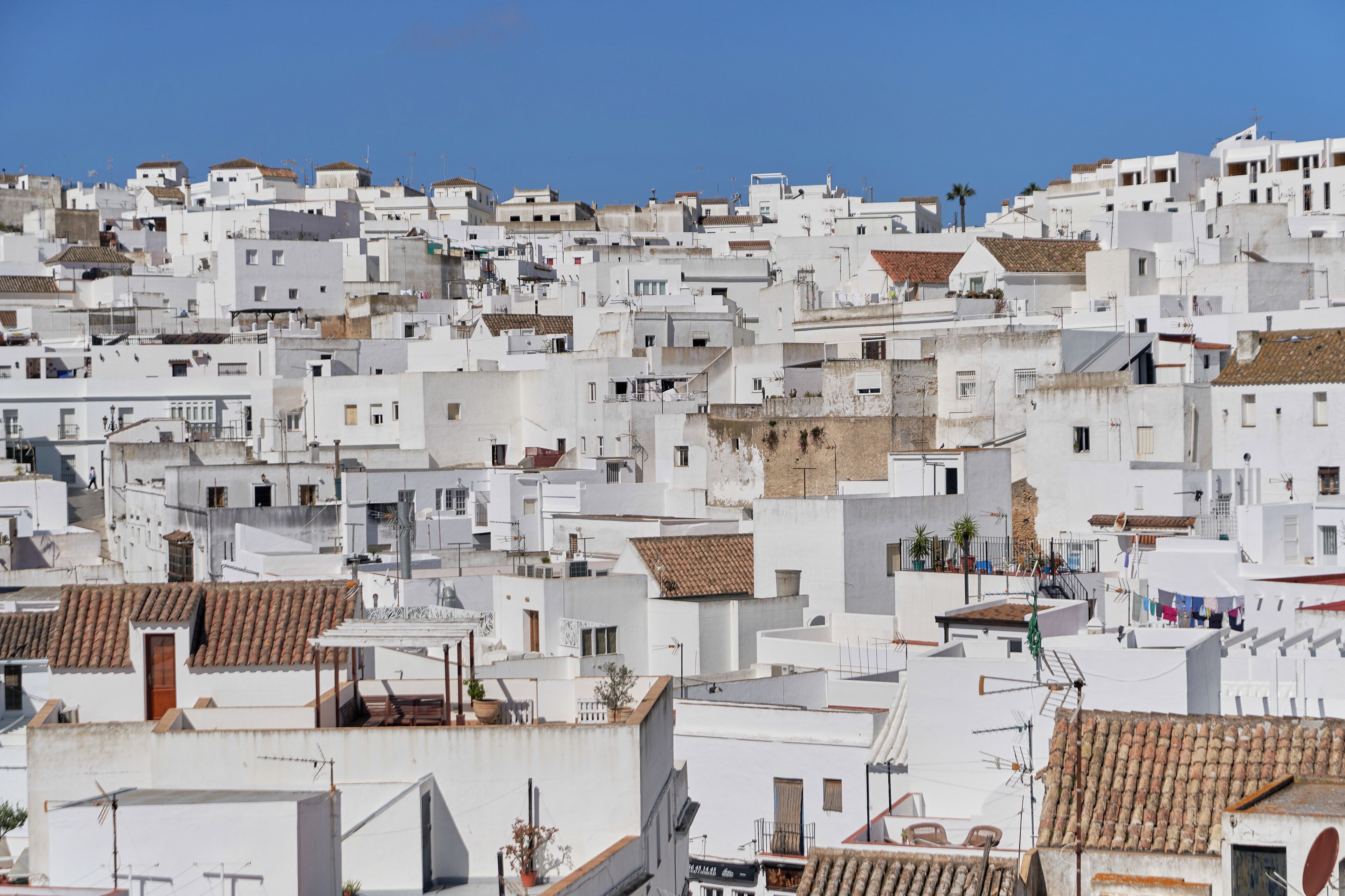 A densely packed urban area with white buildings and terracotta roofs.