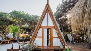 A wooden A-frame structure with a glass door and a wooden deck leading to it. - TAIGA Conil (Conil de la Frontera)