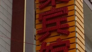 Un edificio con un letrero vertical que muestra caracteres chinos.