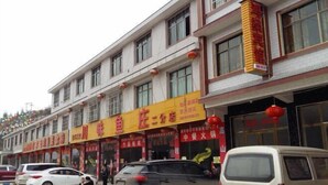 Una hilera de edificios con locales comerciales, incluyendo un restaurante con un letrero amarillo llamativo.