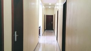 Un pasillo largo y estrecho con puertas a ambos lados, que conduce a una habitación al final.