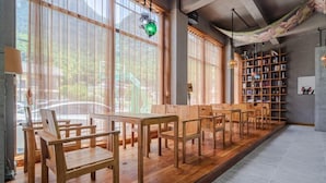 A spacious room with large windows, wooden furniture, and a bookshelf. - Zimu Villa (Zhangjiajie National Forest Park Zimugang Ticket Station) (Zhangjiajie)