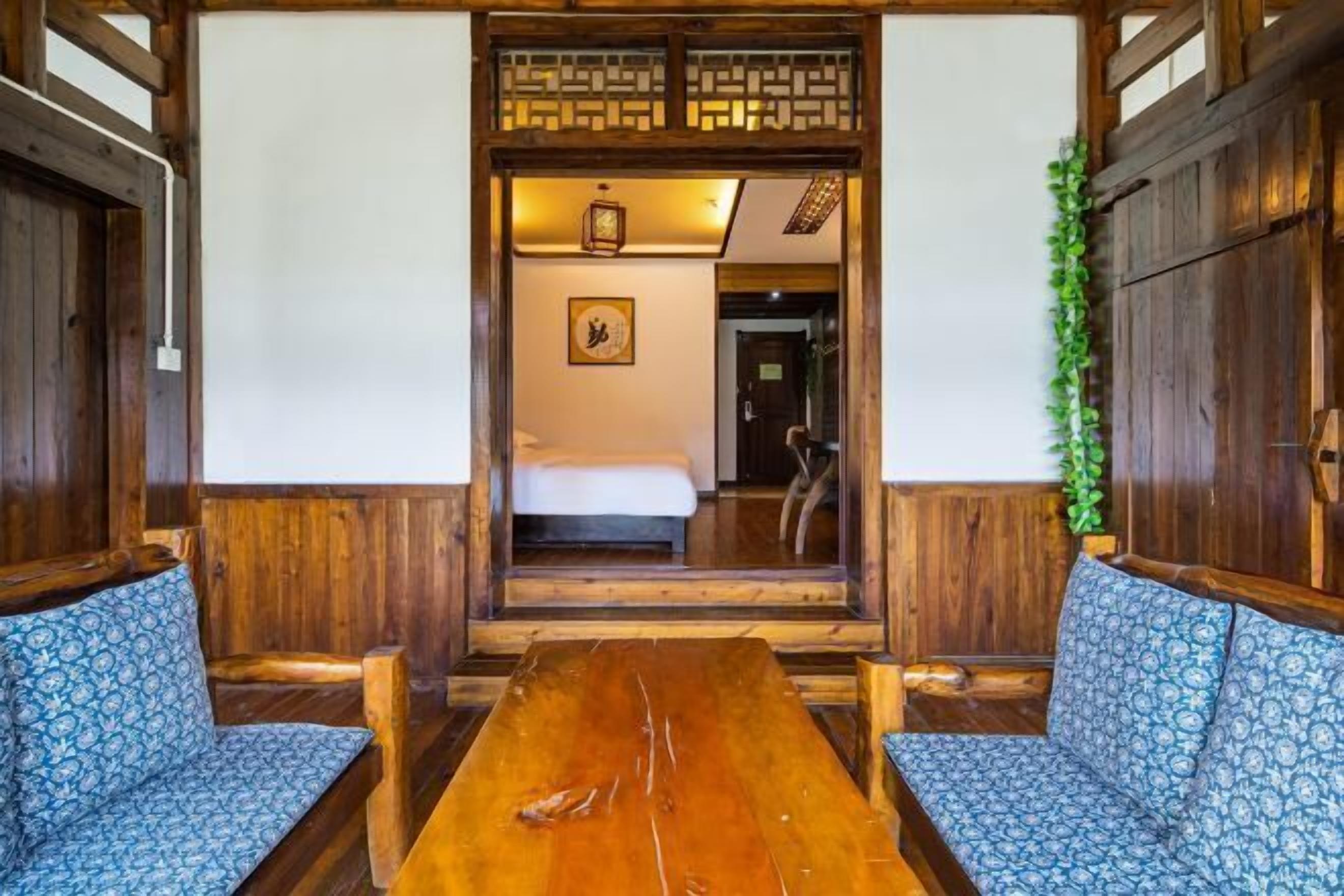 Una habitación de madera tradicional con una mesita baja y dos sofás estampados.