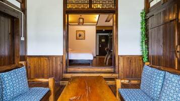 Una habitación de madera tradicional con una mesita baja y dos sofás estampados.