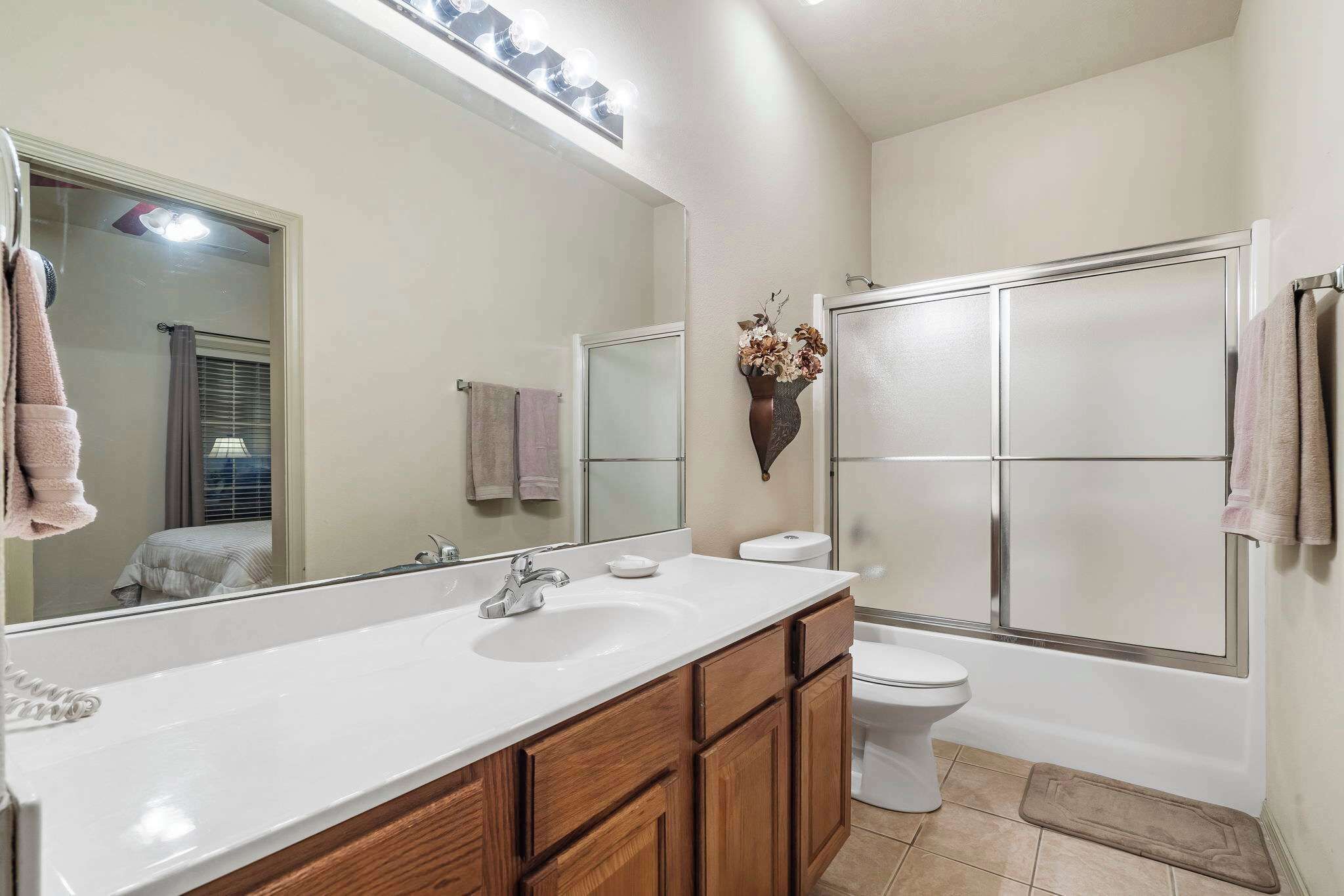 Une salle de bain avec un grand miroir, un lavabo et des toilettes.