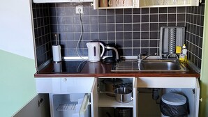 A compact kitchen with a sink, stove, and storage cabinets. - Apartment 9 With a Double bed (Split)