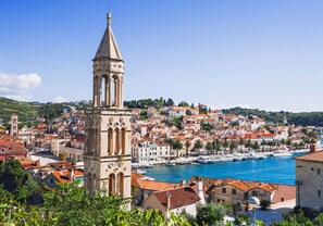A coastal town with a prominent tower, red-roofed buildings, and a marina with boats. - Apartment 9 With a Double bed (Split)