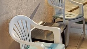 Two white plastic chairs with blue cushions, positioned next to a wall and a tiled floor. - Apartment 9 With a Double bed (Split)
