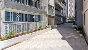 A narrow urban street with modern buildings, a gated entrance, and a paved walkway. - Beautiful 2-bed Apartment in Nairobi (Nairobi)