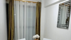 A dining area with a round table, white chairs, a gold vase, and a fluffy rug. - Beautiful 2-bed Apartment in Nairobi (Nairobi)