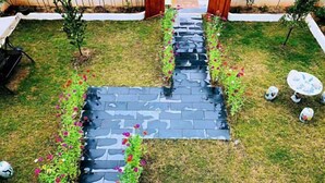 A garden with a stone pathway, small trees, and a white fence. - Huashu Theme Inn (Wuyuan)
