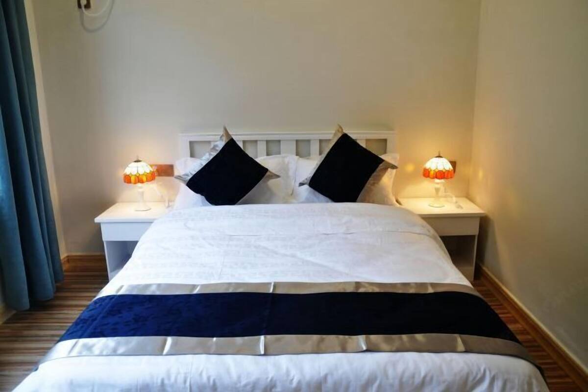 Ein Hotelzimmer mit einem Bett, zwei Nachttischen und Lampen.