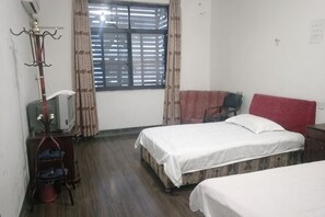 A bedroom with two beds, a TV, a wardrobe, and a window with blinds. - Kangfulai Hotel (Shengzhou)