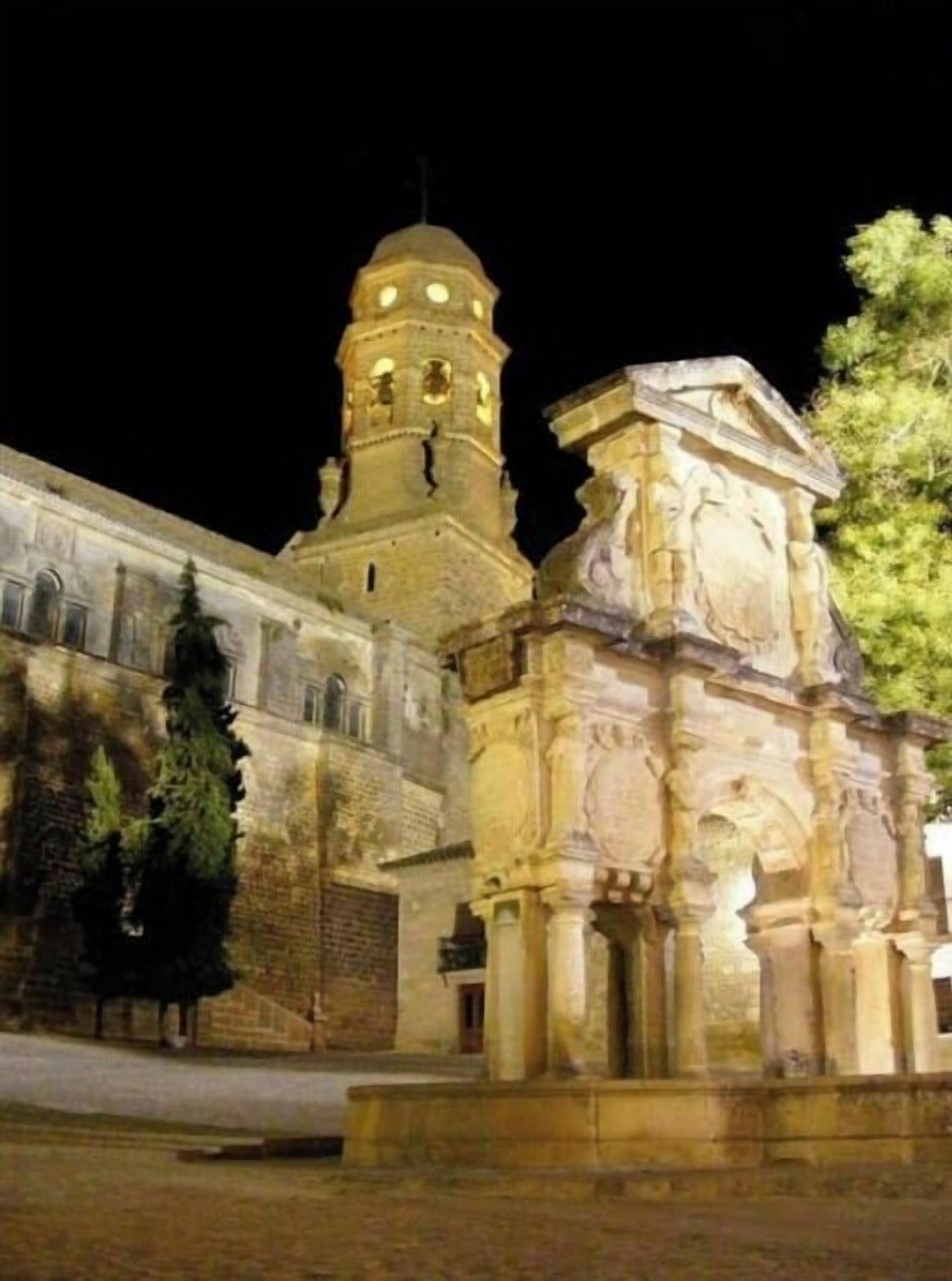 A historic building with a prominent tower and a smaller structure with classical columns.