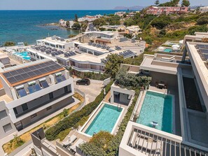 Zona residencial amb edificis moderns, panells solars i piscines.