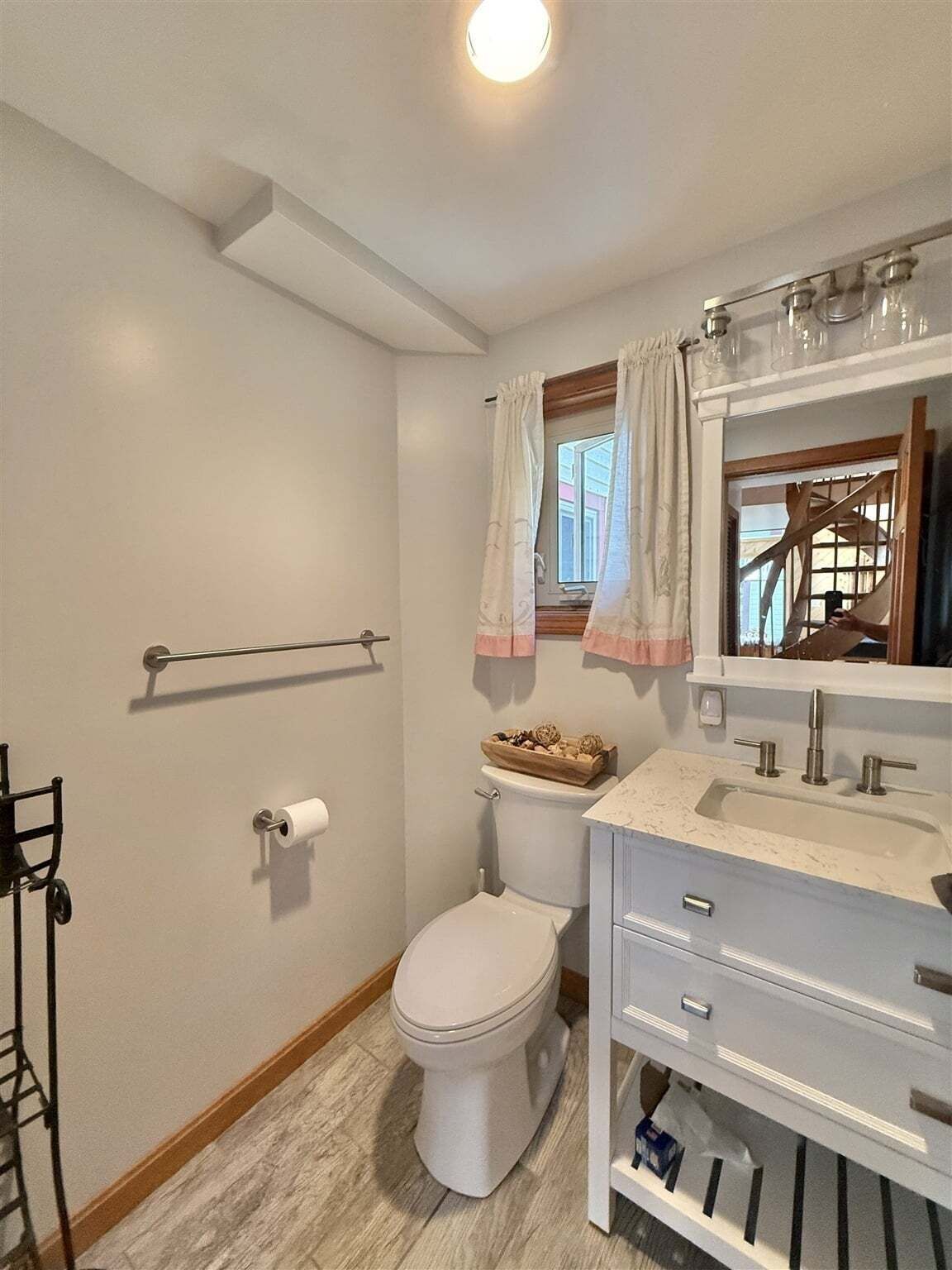 Une salle de bain avec des toilettes, un lavabo et un miroir.