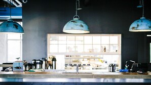 A kitchen counter with a sink, a coffee machine, and a window with a view of the interior. - Billnäsin ruukki (Raseborg)