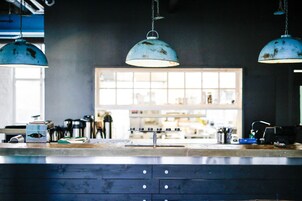 Una encimera de cocina con un lavabo, una cafetera y una ventana con vistas al interior.