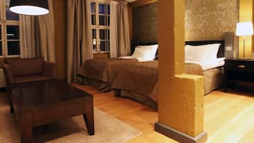 Habitación de hotel con cama, una silla, una mesa y una lámpara.