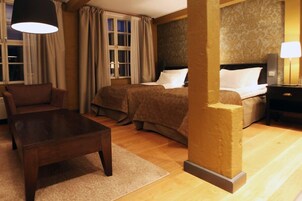 Habitación de hotel con cama, una silla, una mesa y una lámpara.