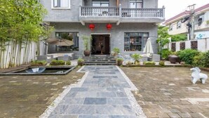 A two-story building with a stone pathway leading to the entrance. - Cili Ciwai Hostel (Jingdezhen)