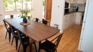A modern kitchen with white cabinets, a wooden dining table, and black chairs. - 5BR Home w/ Saltwater Pool – Pet Friendly, Near Seacliff Beach & Marion | Ideal for Extended Stays (Seacliff Park)