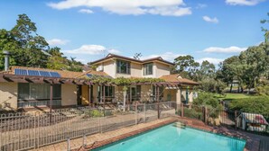 A two-story house with a swimming pool, solar panels, and a fenced yard. - 5BR Home w/ Saltwater Pool – Pet Friendly, Near Seacliff Beach & Marion | Ideal for Extended Stays (Seacliff Park)