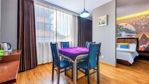 Moderni huone, jossa on ruokapöytä, tuoleja ja sohva.