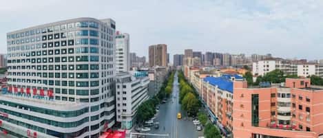 A cityscape with modern buildings, a clear sky, and a busy street.