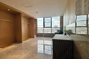 A modern hotel room with a large window, a tiled floor, and a small table. - Jinjiang Hotel International Hotel (Feng County)