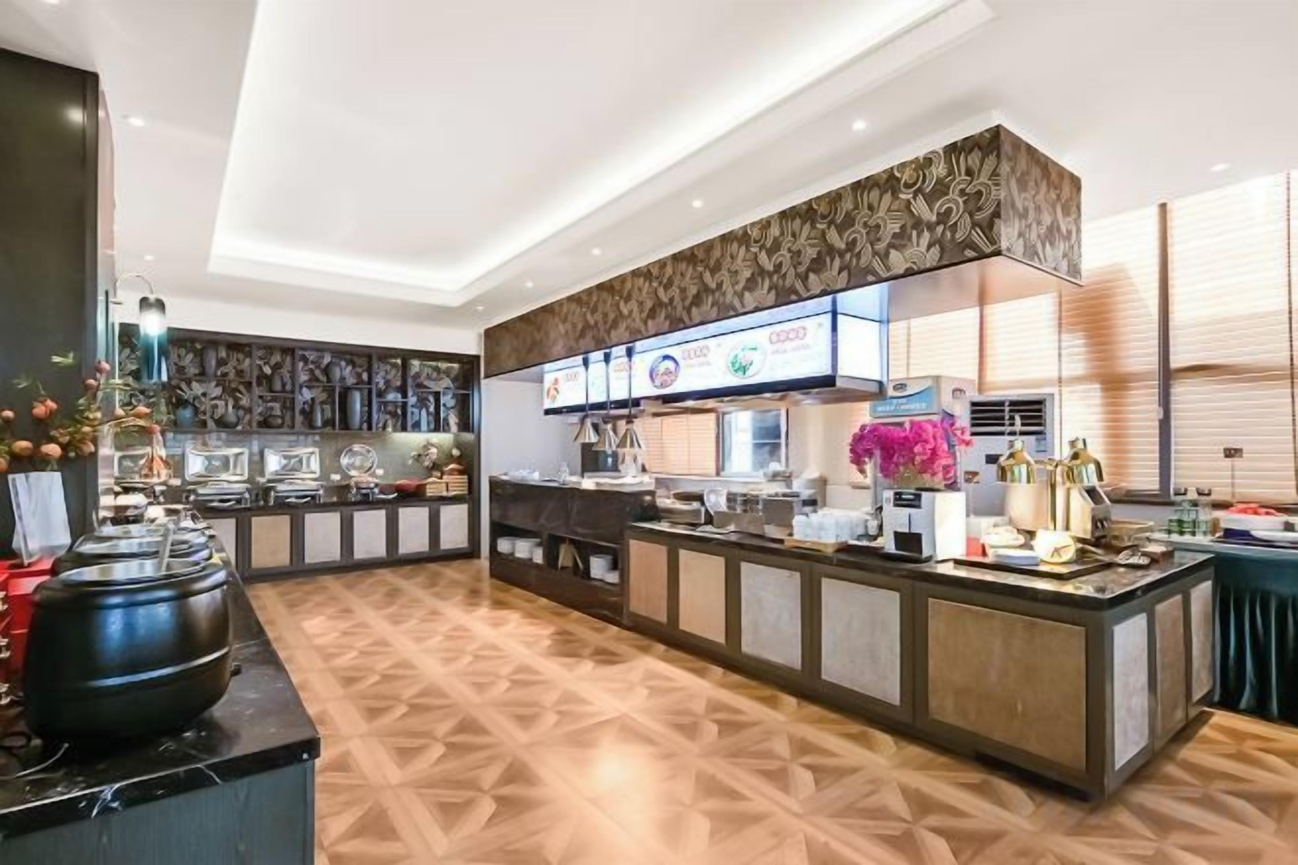 A modern hotel lobby with a reception desk, a large decorative vase, and a patterned floor.