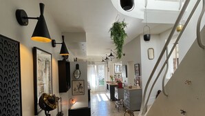 A modern interior with a staircase, black pendant lights, and a hanging plant. - Maison Simone, cosy and private garden - Centre Arles - 2 bedrooms. (Arles)