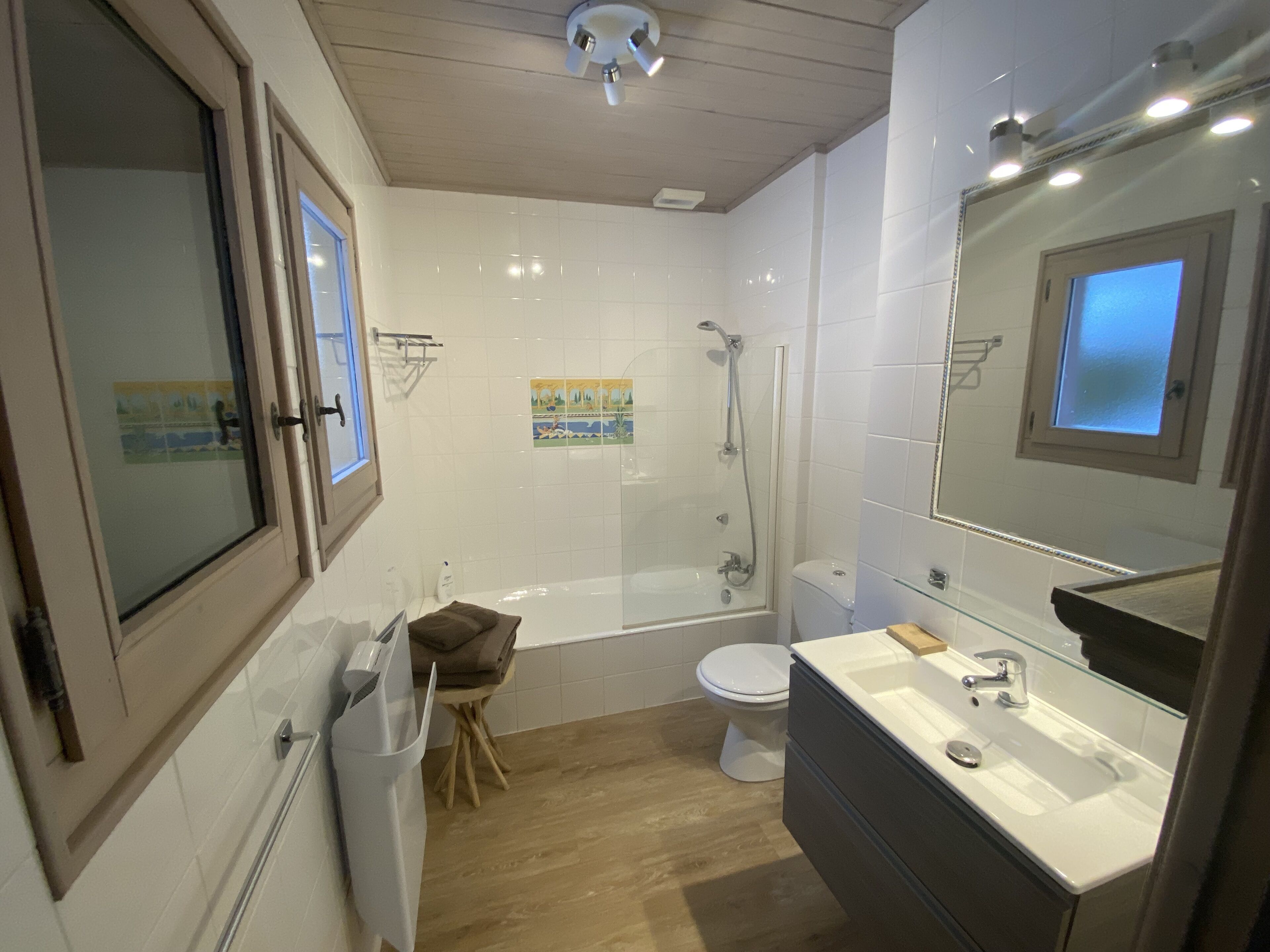 A modern bathroom with a bathtub, toilet, and sink.
