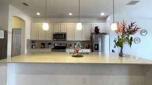 A modern kitchen with white cabinets, stainless steel appliances, and pendant lighting. - Luxury 13 Bedroom Villa in Orlando , Orlando Villa 6269 (Davenport)