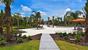A resort pool area with lounge chairs, palm trees, and a clear sky. - Luxury 13 Bedroom Villa in Orlando , Orlando Villa 6269 (Davenport)